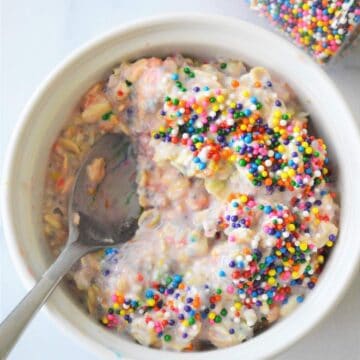 A bowl of funfetti overnight oats with a bite taken out of it.